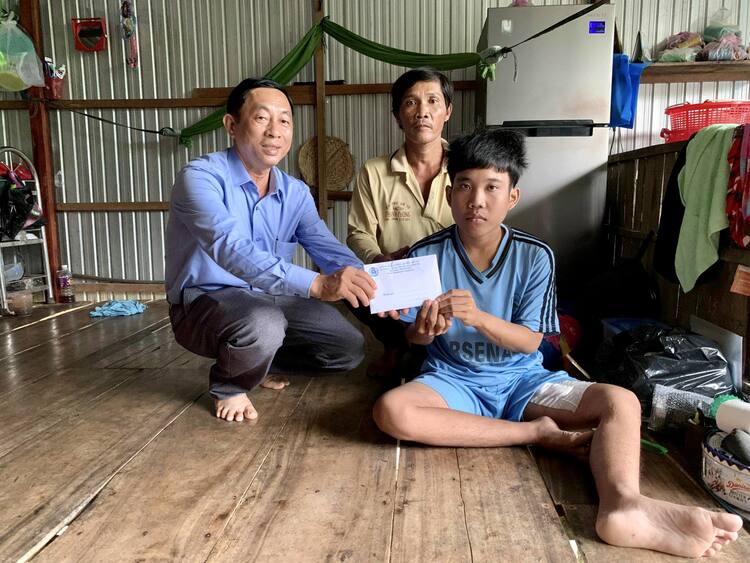 Đ/c Trần Ngọc Trung - Chủ tịch LĐLĐ huyện thăm hỏi tình hình sức khoẻ và trao tặng số tiền 10 triệu đồng cho em Nguyễn Văn Trạng